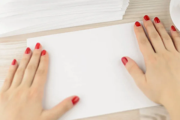 neat office work: Young worker with painted nails pulled the envelope from lying next to stacks and stacks on the table for the convenience of further work