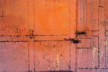 turuncu, paslı, kilitleri olan demir kapı.