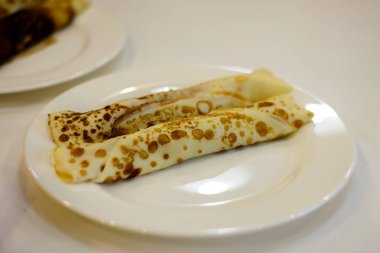 Mutfaktaki beyaz tabağa doldurulmuş gözlemeler.