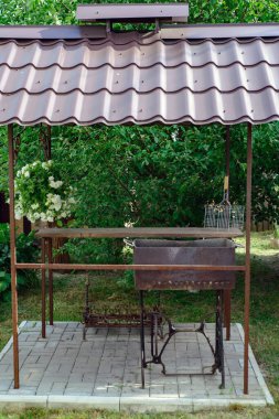 Çimenlikteki bir köy evinin bahçesinde barbekü yapmak için özel donanımlı bir yer.