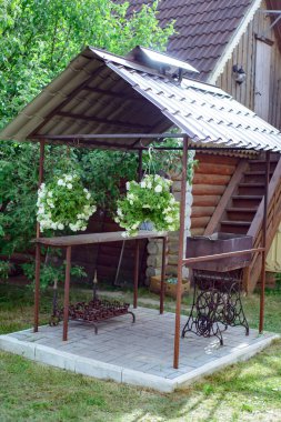 Çimenlikteki bir köy evinin bahçesinde barbekü yapmak için özel donanımlı bir yer.