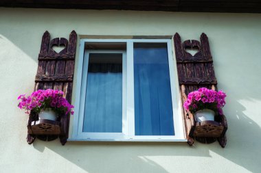 Binanın ön cephesinde oyulmuş kapılar ve saksılar olan bir pencere.