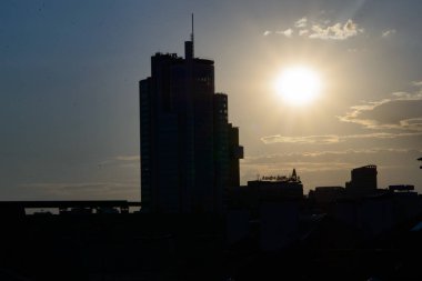 Yüksek modern şehir binası yaz akşamında günbatımının arka planında