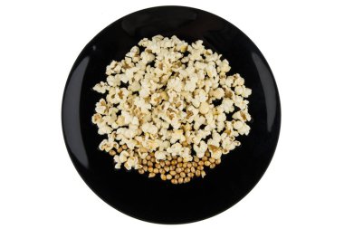 Mikrodalgada patlamış mısırın içinde siyah bir kasede beyaz üzerinde pişirilmiş. Hazırlıksız tahıllar bembeyaz yatıyordu.