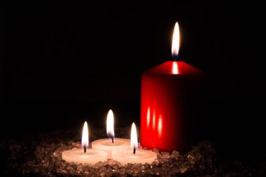 Banyo ve aromaterapi için hazırlıklar: Dört dekoratif mum aromatik deniz tuzunda duruyor ve koyu lavanta kokusu var.