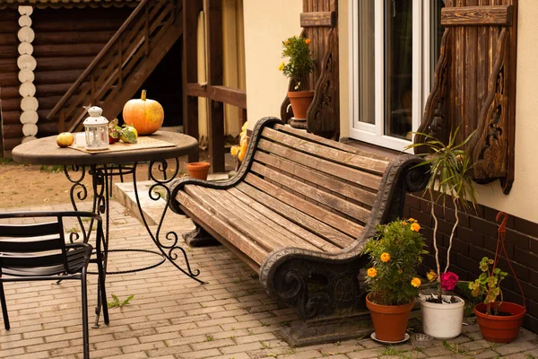 秋家の近くの木のベンチとテーブルにはオレンジのカボチャとリンゴがあります — ストック写真