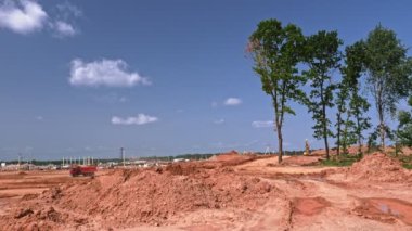 Et işleme tesisinin inşaat alanını dengelemek için toprak taşıyan kargaşaların video görüntüleri.