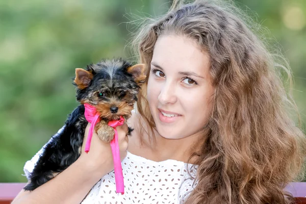 Mulher bela jovem feliz com cabelos longos segurando pequeno cão em — Fotografia de Stock