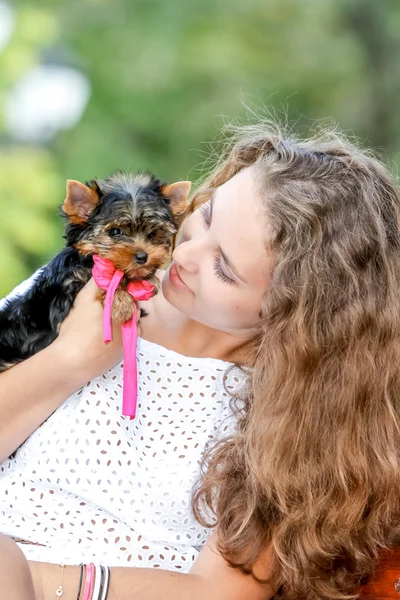 Mulher bela jovem feliz com cabelos longos segurando pequeno cão em — Fotografia de Stock