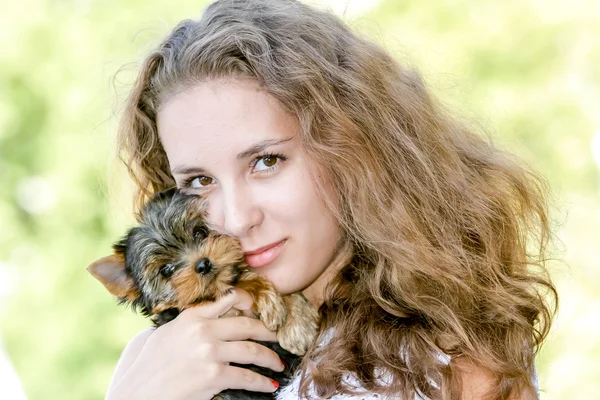 Mulher bela jovem feliz com cabelos longos segurando pequeno cão em — Fotografia de Stock