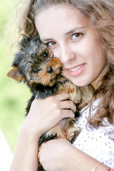 Mulher bela jovem feliz com cabelos longos segurando pequeno cão em — Fotografia de Stock