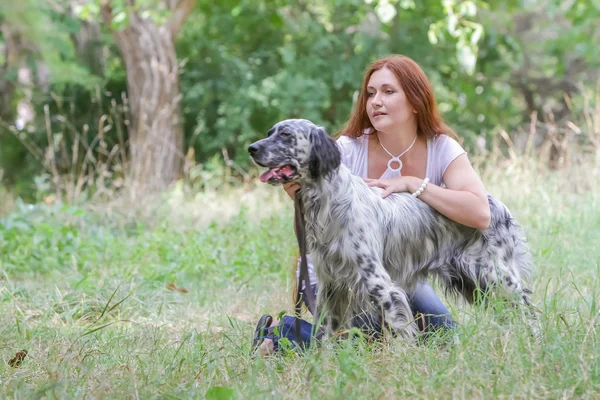 自然な表現の上に犬を持つ若い幸せな女性の屋外のポートレート — ストック写真