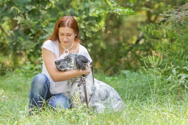 自然な表現の上に犬を持つ若い幸せな女性の屋外のポートレート — ストック写真