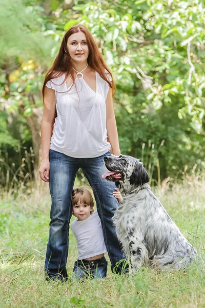 Jovem mãe com criança e cachorro desfrutando de seu tempo na natureza , — Fotografia de Stock