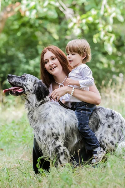 Jovem mãe com criança e cachorro desfrutando de seu tempo na natureza , — Fotografia de Stock