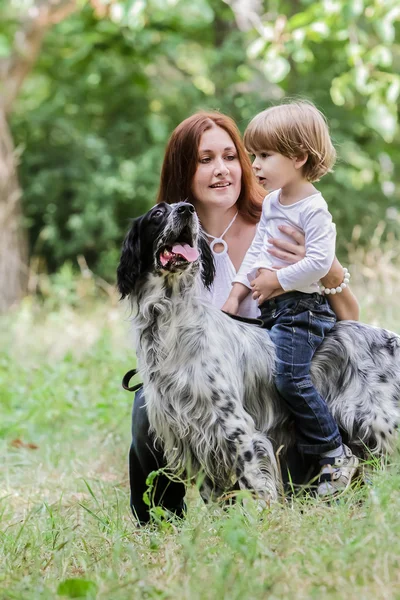 Mladá matka s batoletem a pes užívat svůj čas v přírodě, — Stock fotografie