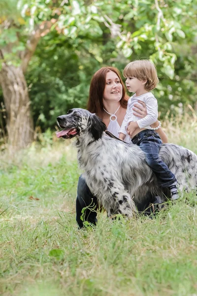 Jovem mãe com criança e cachorro desfrutando de seu tempo na natureza , — Fotografia de Stock