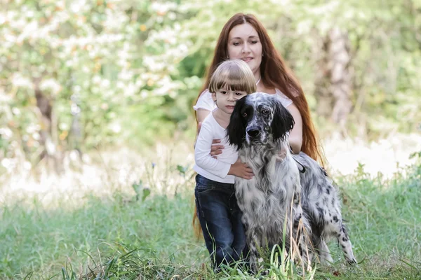 Jovem mãe com criança e cachorro desfrutando de seu tempo na natureza , — Fotografia de Stock