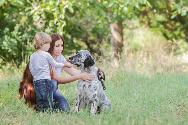 Jovem mãe com criança e cachorro desfrutando de seu tempo na natureza , — Fotografia de Stock