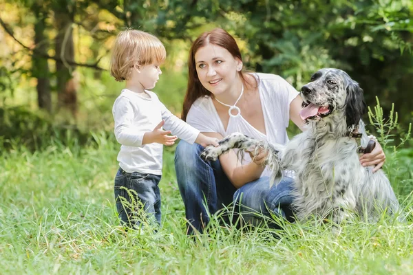 Jeune mère avec tout-petit et chien profitant de leur temps sur la nature , — Photo