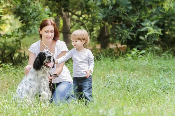 Jovem mãe com criança e cachorro desfrutando de seu tempo na natureza , — Fotografia de Stock