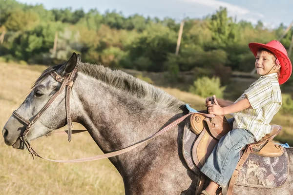 Kültéri álló fiatal boldog fiú lovaglás egy ló farm, rura — Stock Fotó