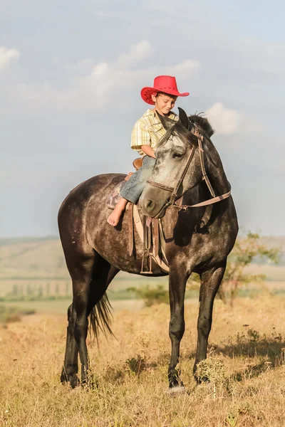 Outdoor Portret van gelukkige jongen berijden van een paard op de boerderij, rura — Stockfoto