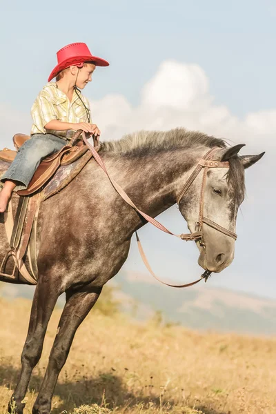 Außenporträt eines glücklichen Jungen auf einem Pferd auf einem Bauernhof, rura — Stockfoto