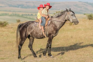 iki genç mutlu çocuklar bir çiftlikte, açık portre üzerinde binicilik