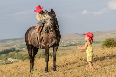 iki genç mutlu çocuklar bir çiftlikte, açık portre üzerinde binicilik