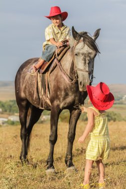 iki genç mutlu çocuklar bir çiftlikte, açık portre üzerinde binicilik