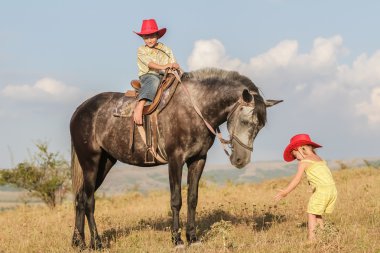 iki genç mutlu çocuklar bir çiftlikte, açık portre üzerinde binicilik
