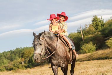 iki genç mutlu çocuklar bir çiftlikte, açık portre üzerinde binicilik