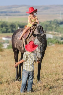 iki genç mutlu çocuklar bir çiftlikte, açık portre üzerinde binicilik
