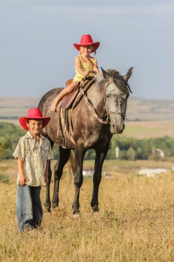 iki genç mutlu çocuklar bir çiftlikte, açık portre üzerinde binicilik