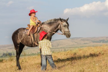 iki genç mutlu çocuklar bir çiftlikte, açık portre üzerinde binicilik