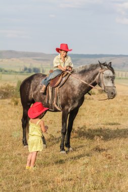 iki genç mutlu çocuklar bir çiftlikte, açık portre üzerinde binicilik