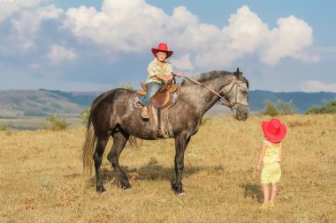 iki genç mutlu çocuklar bir çiftlikte, açık portre üzerinde binicilik