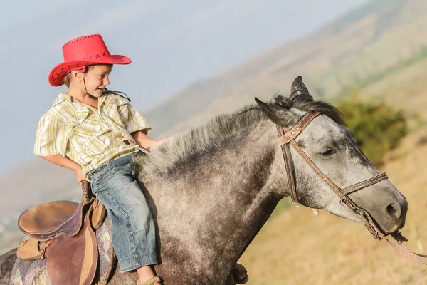 Outdoor Portret van gelukkige jongen berijden van een paard op de boerderij, rura — Stockfoto