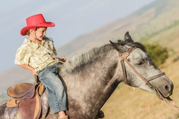 Kültéri álló fiatal boldog fiú lovaglás egy ló farm, rura — Stock Fotó