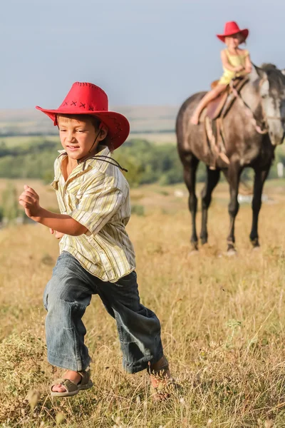 两个年轻快乐的孩子骑一匹马在农场，室外肖像 — 图库照片