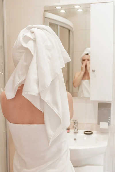 Bella donna che applica la crema sul suo viso in bagno — Foto Stock