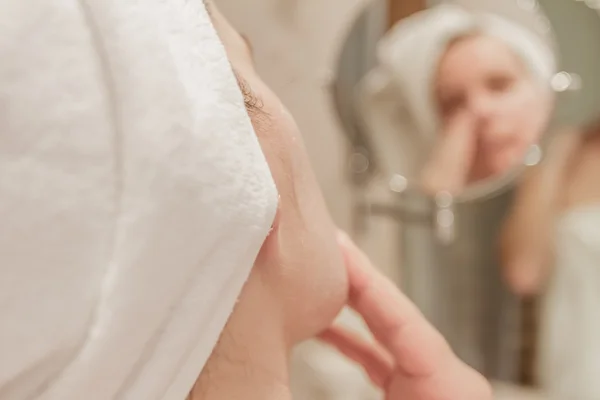 Bella donna che applica la crema sul suo viso in bagno — Foto Stock