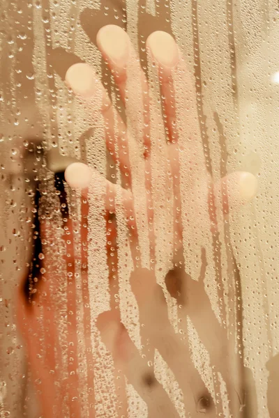 Ritratto sfocato di una donna che fa la doccia attraverso lo schermo del bagno — Foto Stock