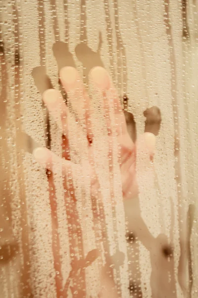 Unfocused portrait of a woman showering through the bath screen — Stock Photo, Image