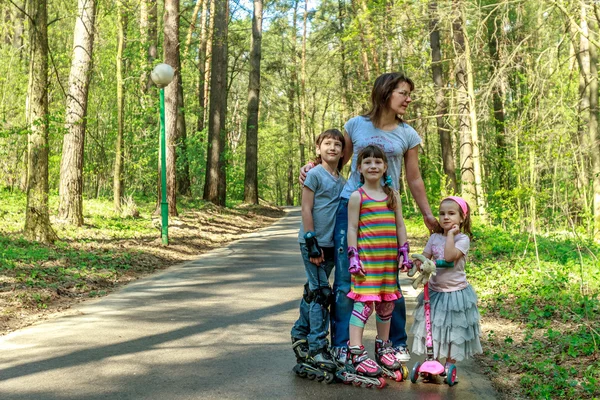 Les jeunes filles et les garçons en équipement de protection et rouleaux scating — Photo