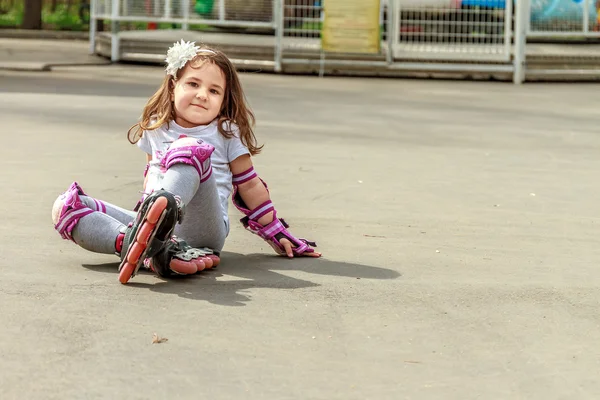 Giovane ragazza in attrezzature protettive e rulli si trova sulla passerella — Foto Stock