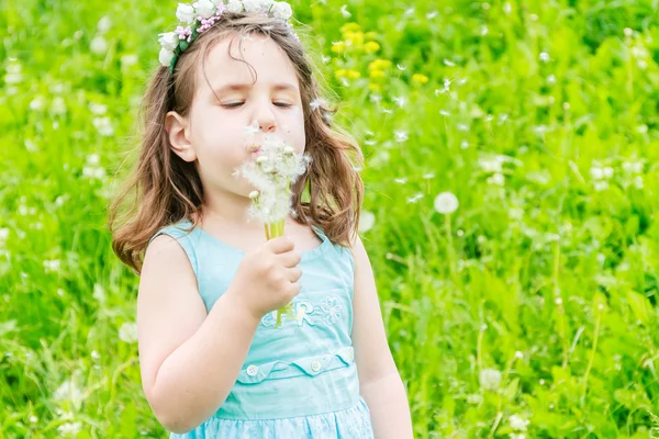 Schöne Kind Mädchen mit Löwenzahnblüte im Frühlingspark. glücklich — Stockfoto