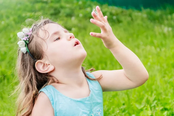 Bella bambina con fiore di tarassaco nel parco primaverile. Felice. — Foto Stock