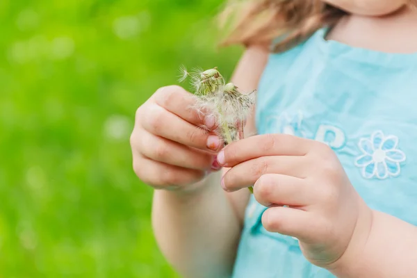 Menina bonita com flor de dente de leão no parque de primavera. Feliz. — Fotografia de Stock